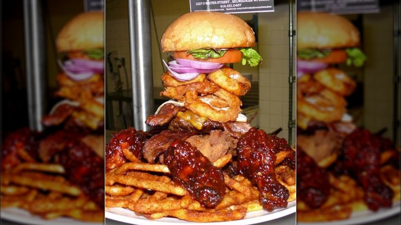 Giant burger with onion rings, fries, and hot wings