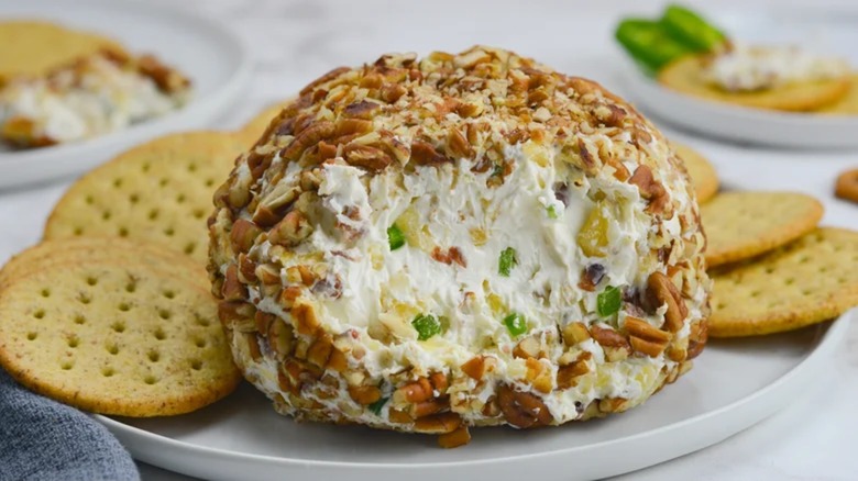 Bacon jalapeño pineapple cheese ball on plate with crackers
