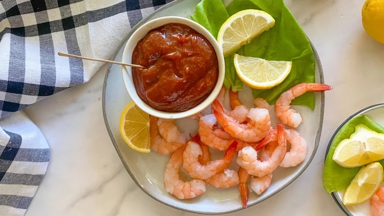 Shrimp on plate with cocktail sauce, lemons, and lettuce