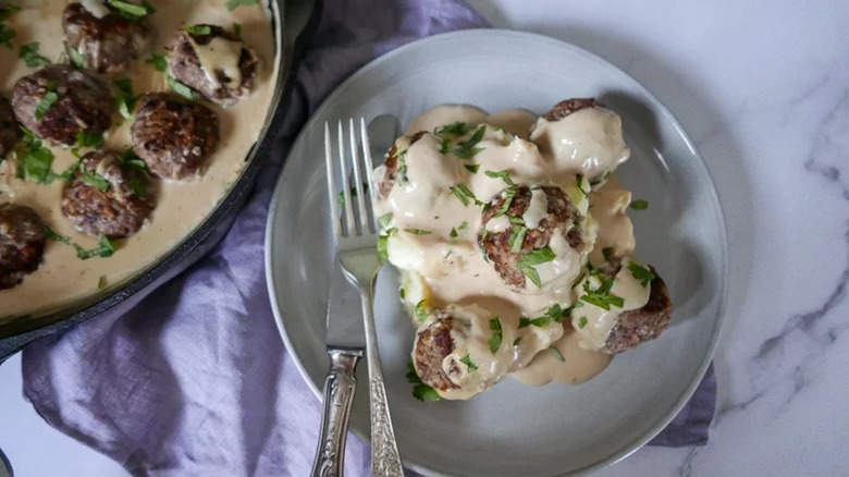 Classic Swedish meatballs in a bowl and on a plate with a fork and knife