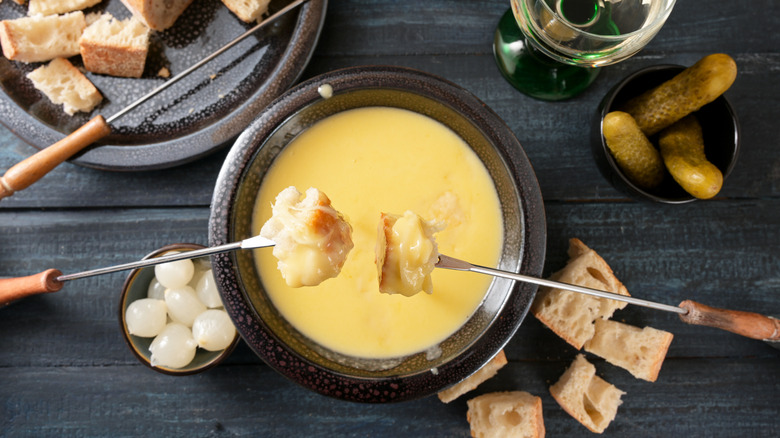 Cubes of bread on forks over a pot of fondue