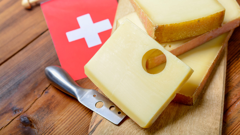 Emmentaler cheese pictured with a small Swiss flag