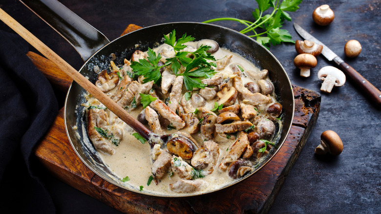 A pan of Zürcher geschnetzelte, featuring slices of veal in a white sauce