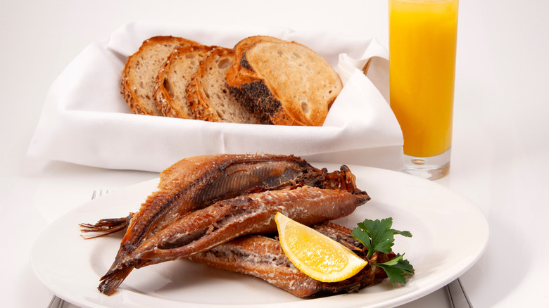 Kippers on plate next to toast and orange juice