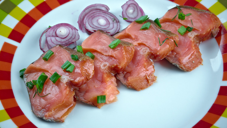 Thick slices of rakfisk on white plate