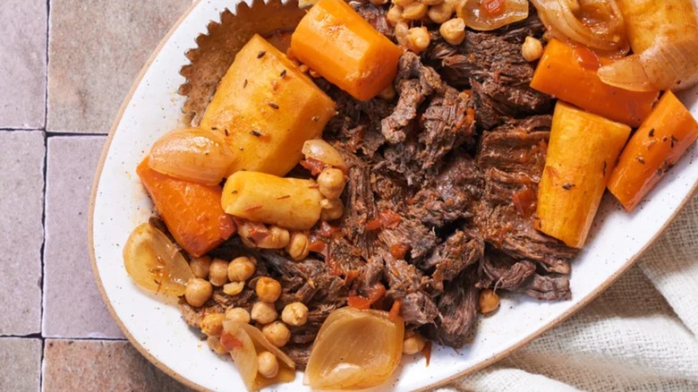 Platter of harissa beef pot roast with carrots, chick peas, and onions