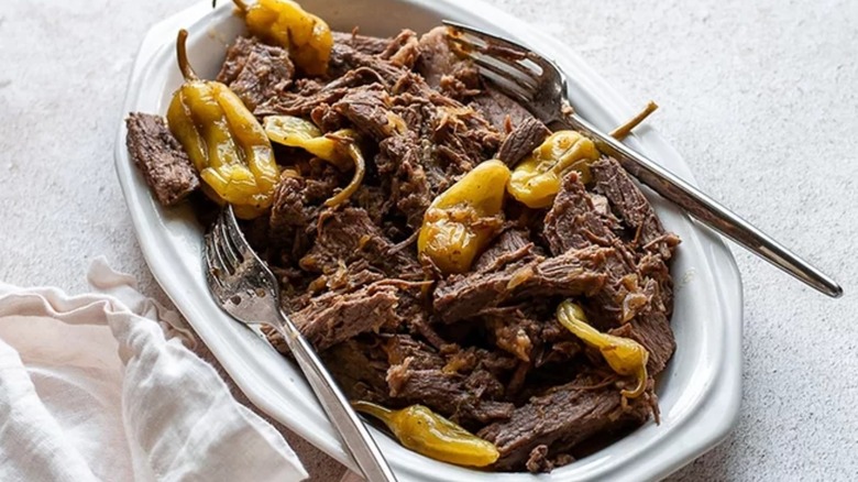 Mississippi roast beef on a platter with pepperoncini peppers