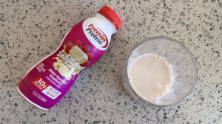 Indulgence White Chocolate Raspberry bottle with a glass cup