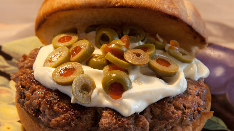 Burger with sliced olives and mayo