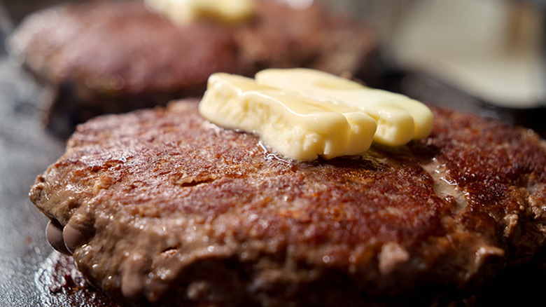 Pat of butter melting on a burger patty
