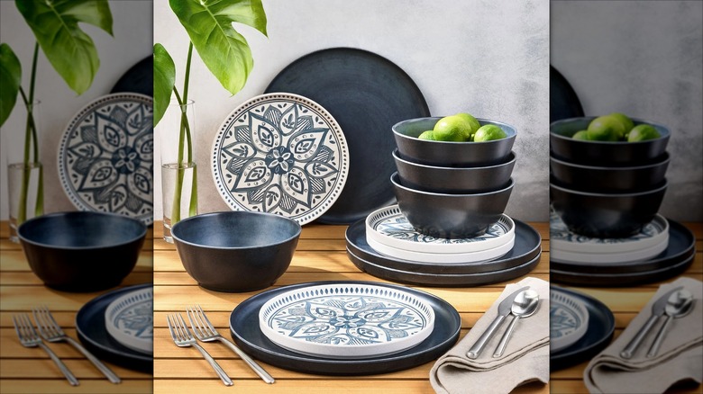 Granite-colored bamboo melamine dinnerware set on wooden tabletop with napkins, cutlery, and a plant