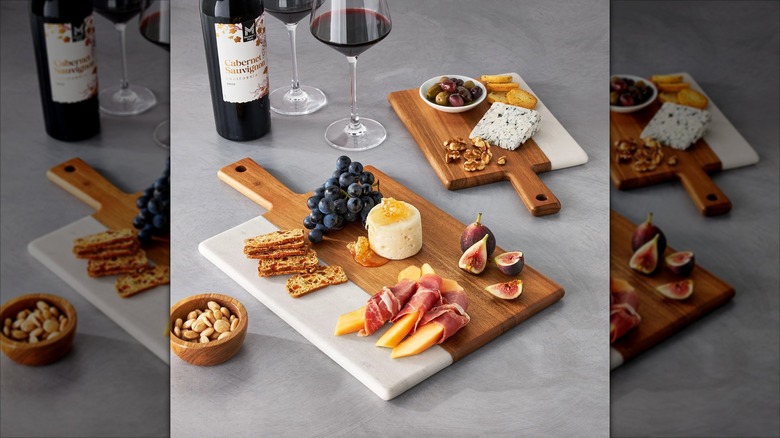 Acacia and marble charcuterie board with charcuterie and wine