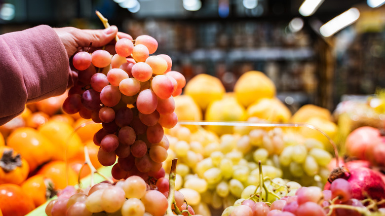 Person checking out grapes at grocery store