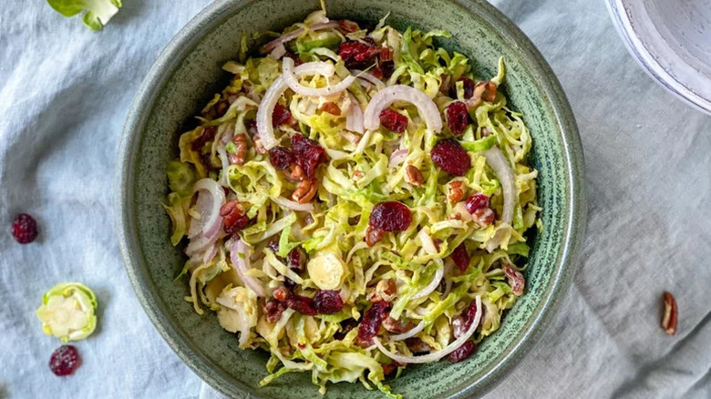 Bowl of Brussels sprouts slaw, topped with dried cranberries