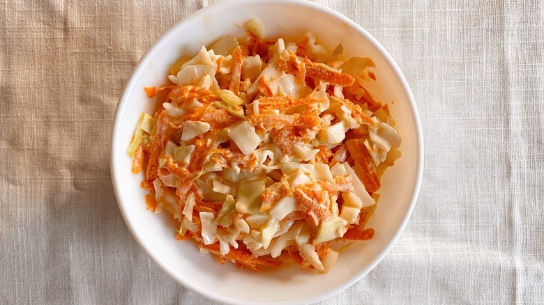 Creamy carrot slaw in white bowl