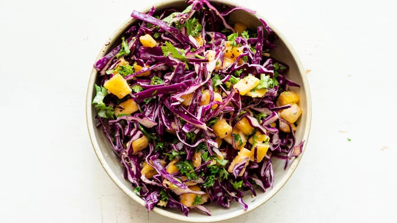 Bowl of red cabbage slaw with pineapple chunks