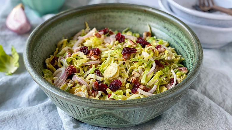 Brussels sprouts slaw with dried cranberries in blue bowl