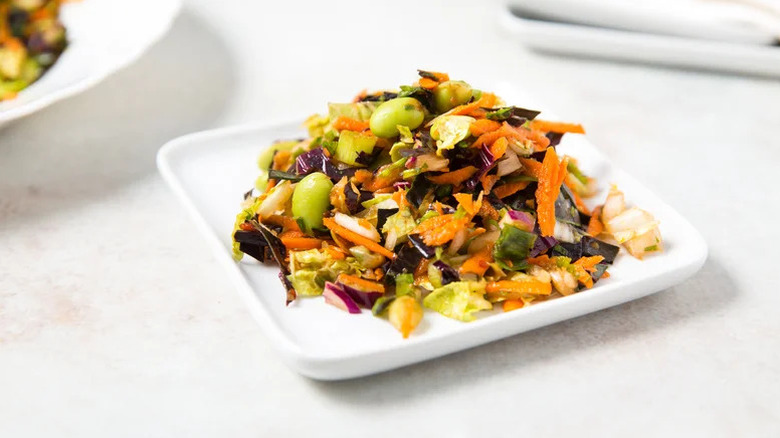 Plate of spicy coleslaw with carrot, red cabbage, and edamame