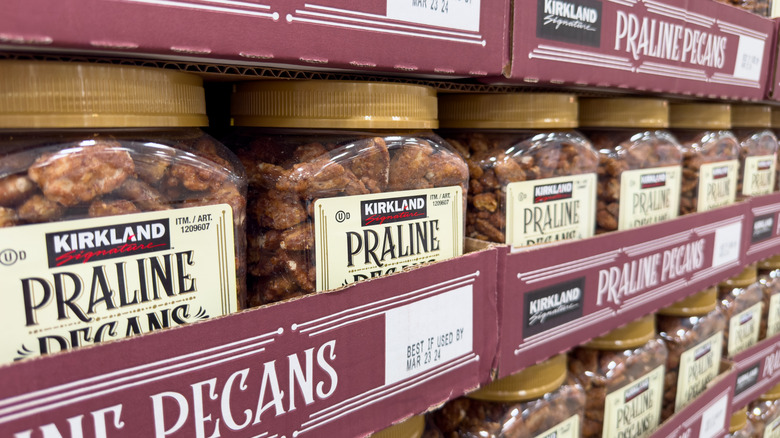 Packs of Kirkland Signature Praline Pecans stacked in cartons on the store shelves