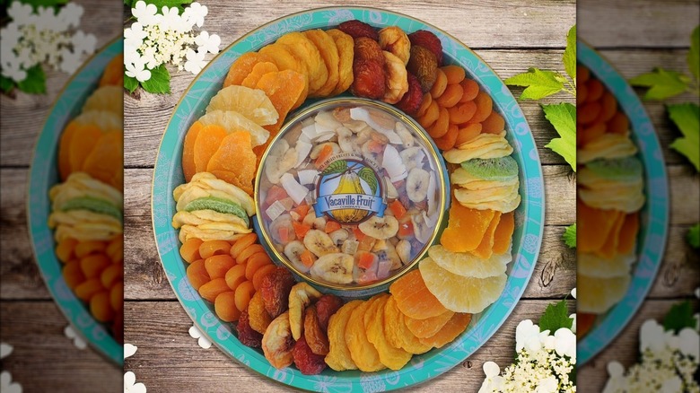 A round teal tray with dried fruit neatly arranged inside of it