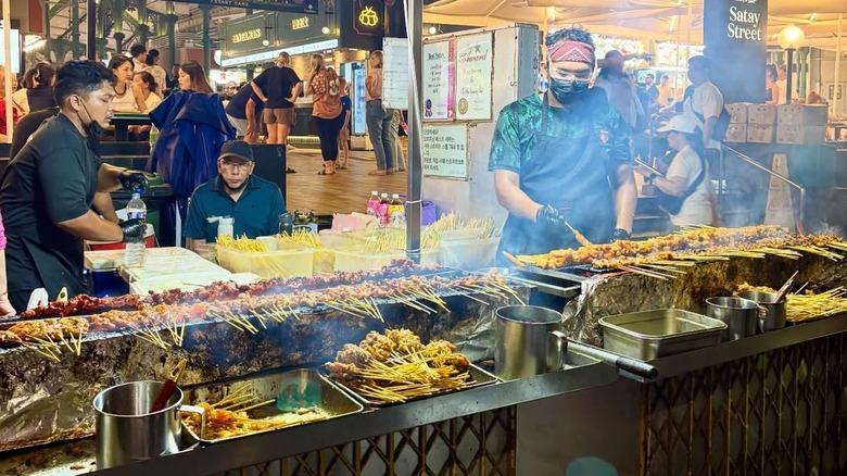 Person cooking satay at Lau Pa Sat food stall