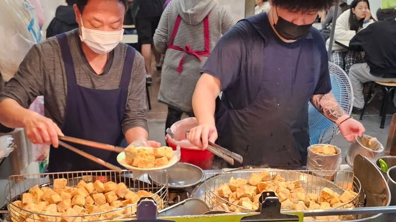 Chefs preparing food at Shilin Night Market stall