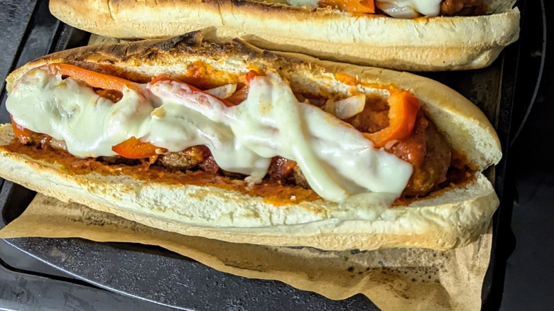 Toasted meatball subs with melted cheese, caramelized onions, and red bell peppers