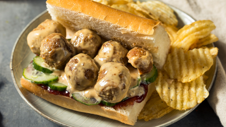 Swedish meatball sub sandwiches with cucumbers on a plate with potato chips
