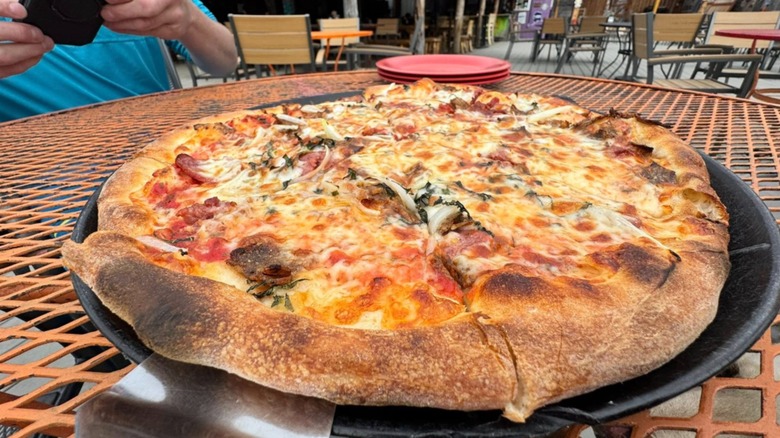 A reindeer pizza with charred crust on a patio of an Alaska restaurant