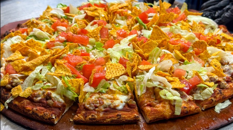 A close-up of a thin crust pizza with taco toppings from Happy Joe's Pizza