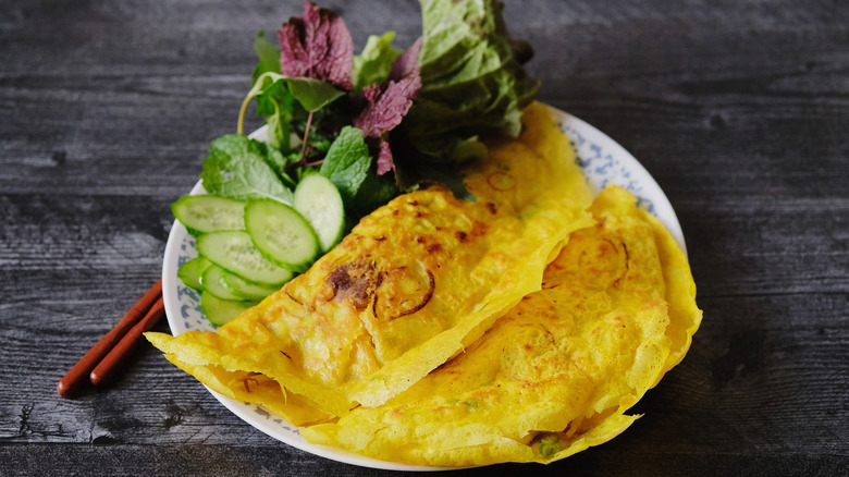 Vietnamese bánh xèo on white plate with salad