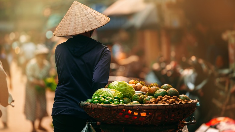 Woman walking in Hoi An with fruits