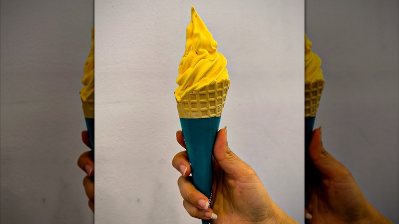 hand holding soft-serve durian ice cream in cone