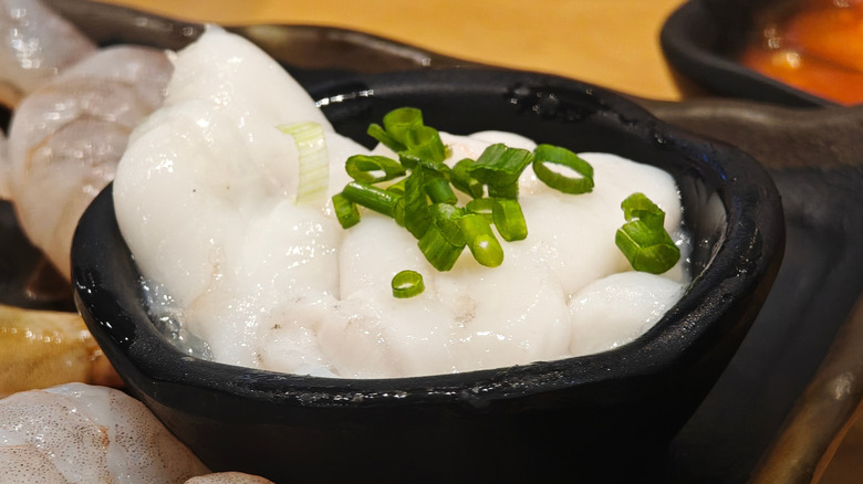 close up on squid with roe in black dish
