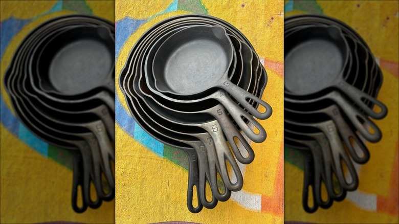Set of seven Griswold cast iron skillets nested on a tablecloth
