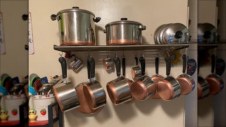 Revere Ware copper cookware set displayed on kitchen wall rack