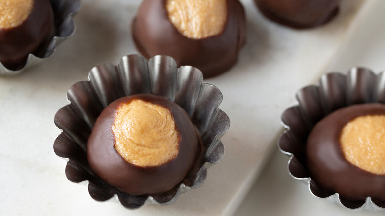 A close-up of buckeyes candies in small aluminium dessert cups