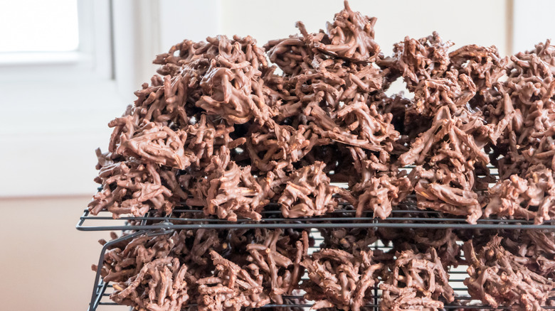 Homemade chocolate haystack cookies stacked on cooling racks