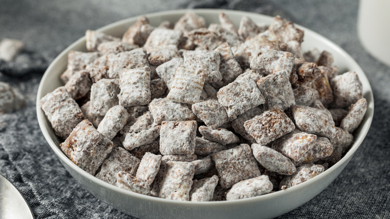 A bowl of Chex cereal covered in chocolate and powdered sugar in a white bowl