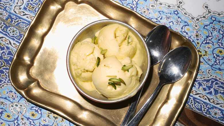 Iranian bastani ice cream in a bowl on a tray with spoons