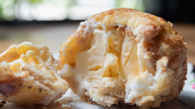 A deep fried ice cream ball cut in half