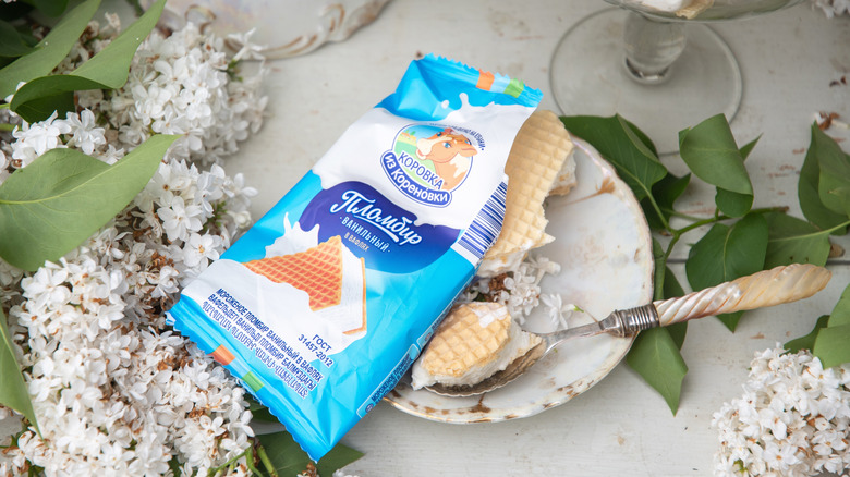 A plombir ice cream sandwich on a plate with a spoon