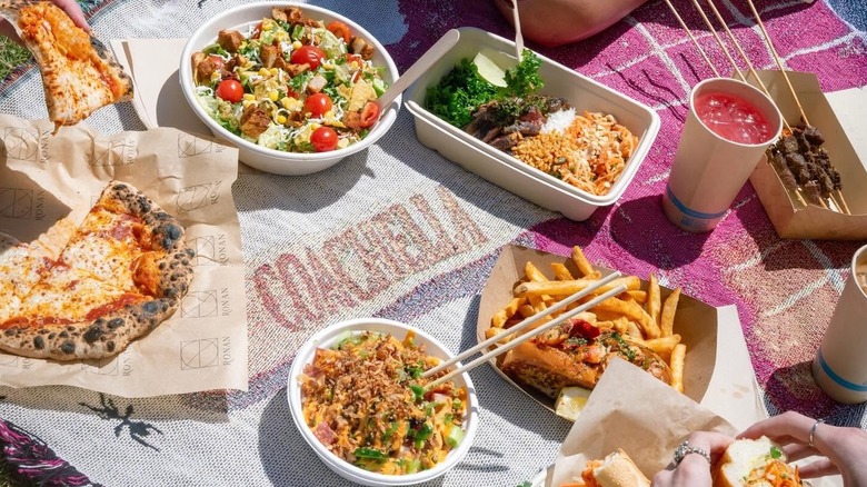 A wide selection of food and drink placed down on a branded Coachella blanket