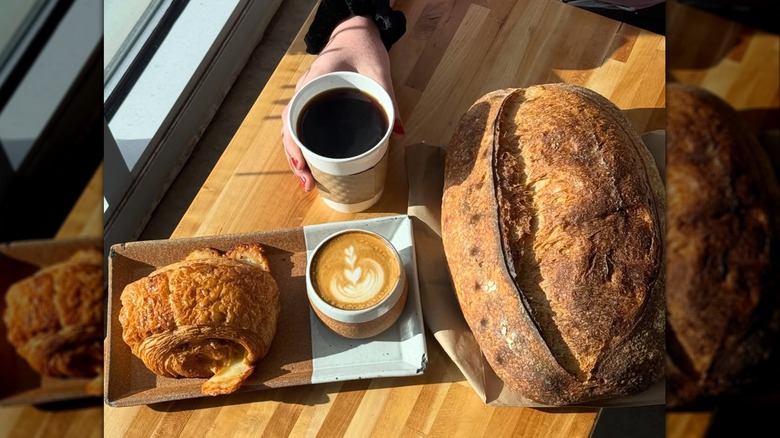 Two cups of coffee next to bread and pastry