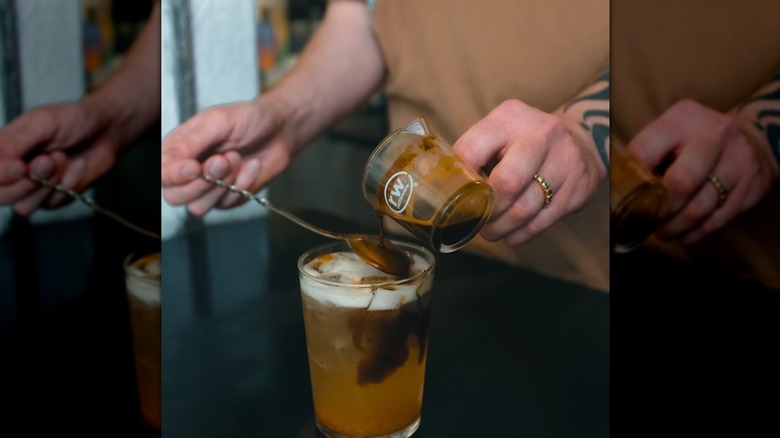 Coffee being poured overtop a cup of ice