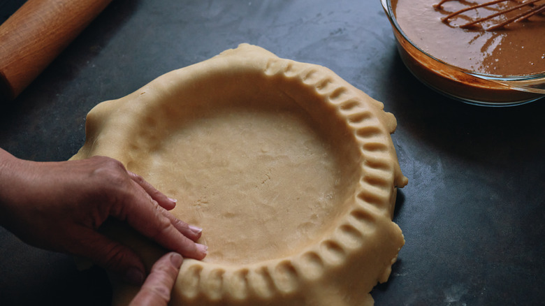 Person preparing pie crust kitchen