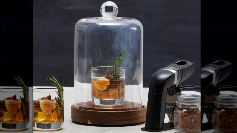 Cocktail with fig and rosemary beneath a glass smoking cloche