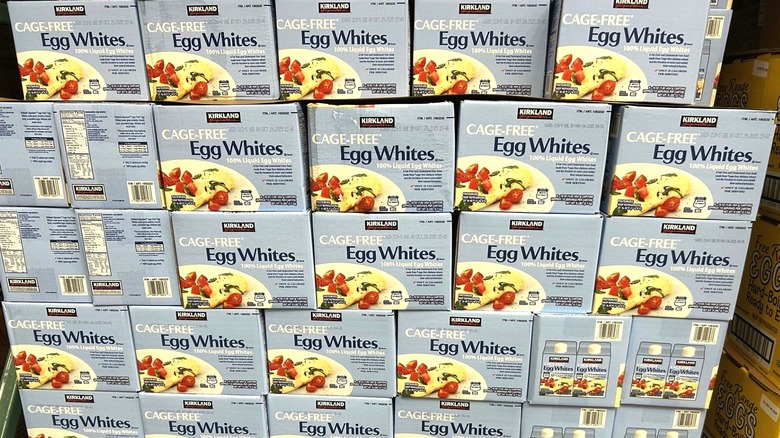 Boxes Kirkland Signature cage-free egg whites stacked in Costco store
