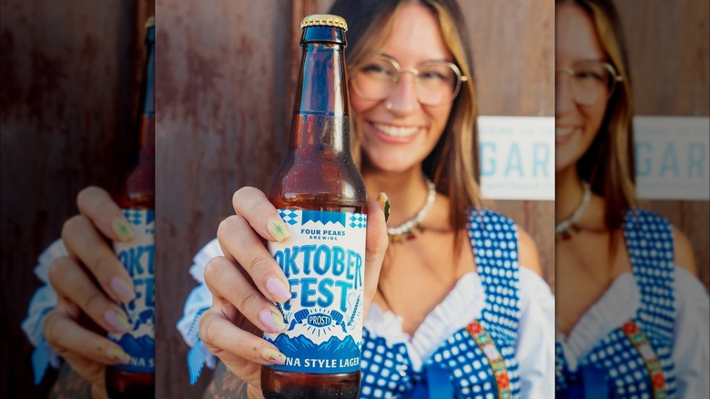 woman in lederhosen holding Four Peaks Brewing Oktoberfest beer