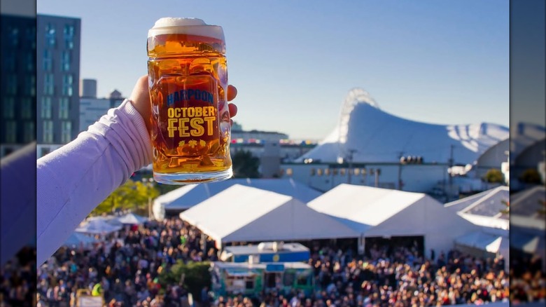 person holding a beer stein over a large crowd at Harpoon Octoberfest